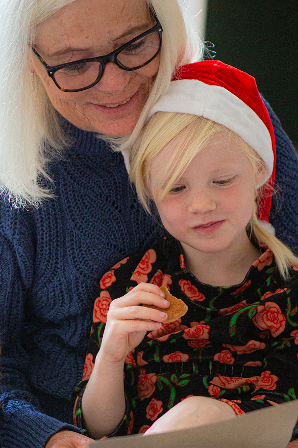 Et close up billede af far og søn som sidder og læser en julehistorie fra Julemandes Posthus