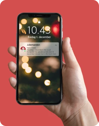 Et billede som viser en telefon med en juleSMS fra julemandens Posthus
